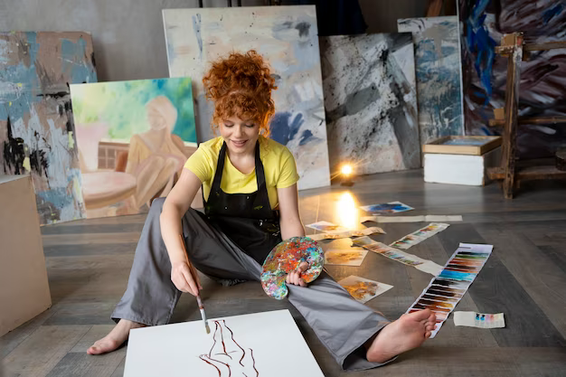 Girl draws a picture while sitting on the floor