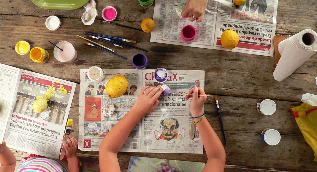 Children coloring toys on a wooden table, top view