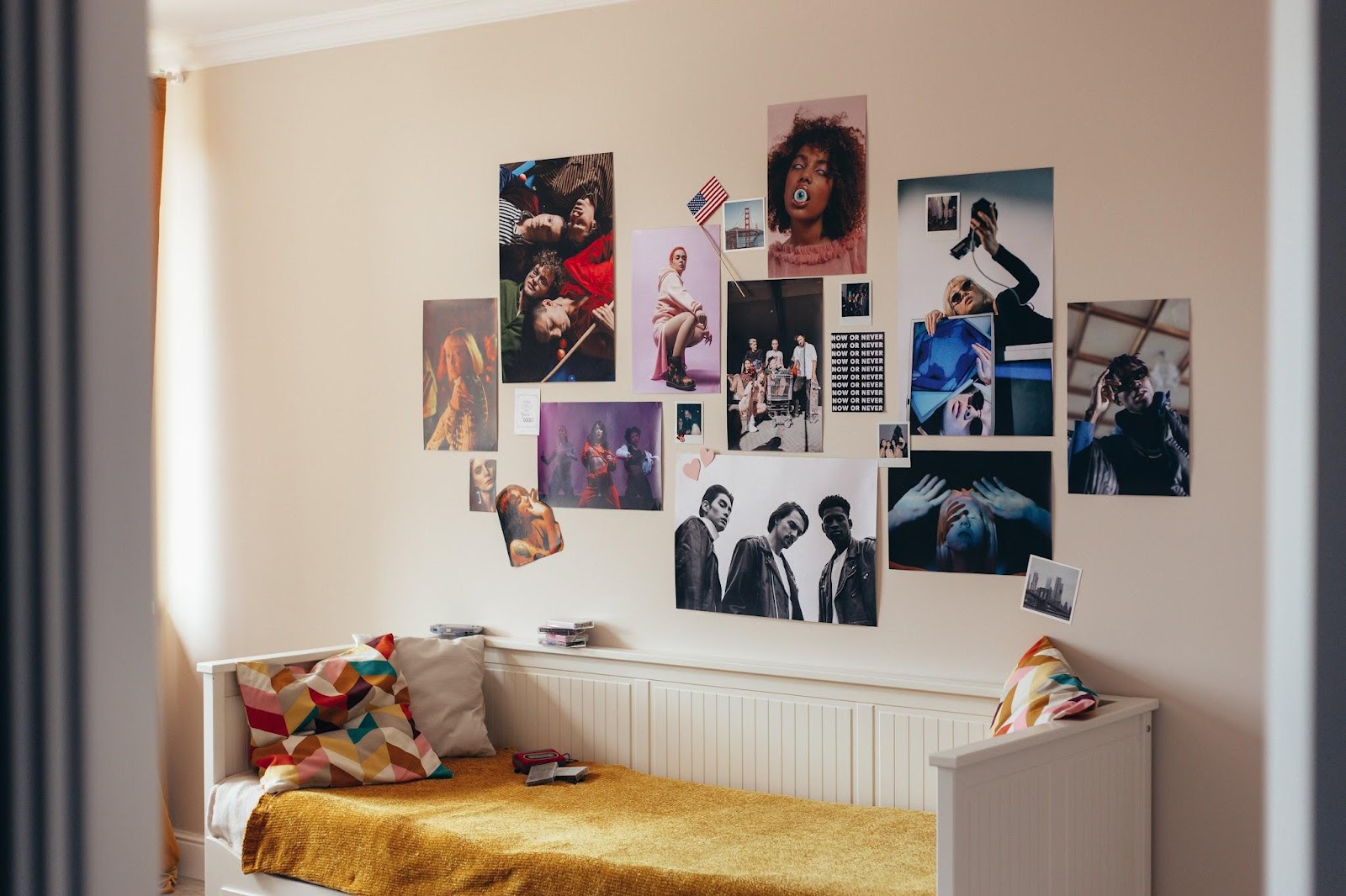 a small teenager’s room with a couch and various posters on the wall