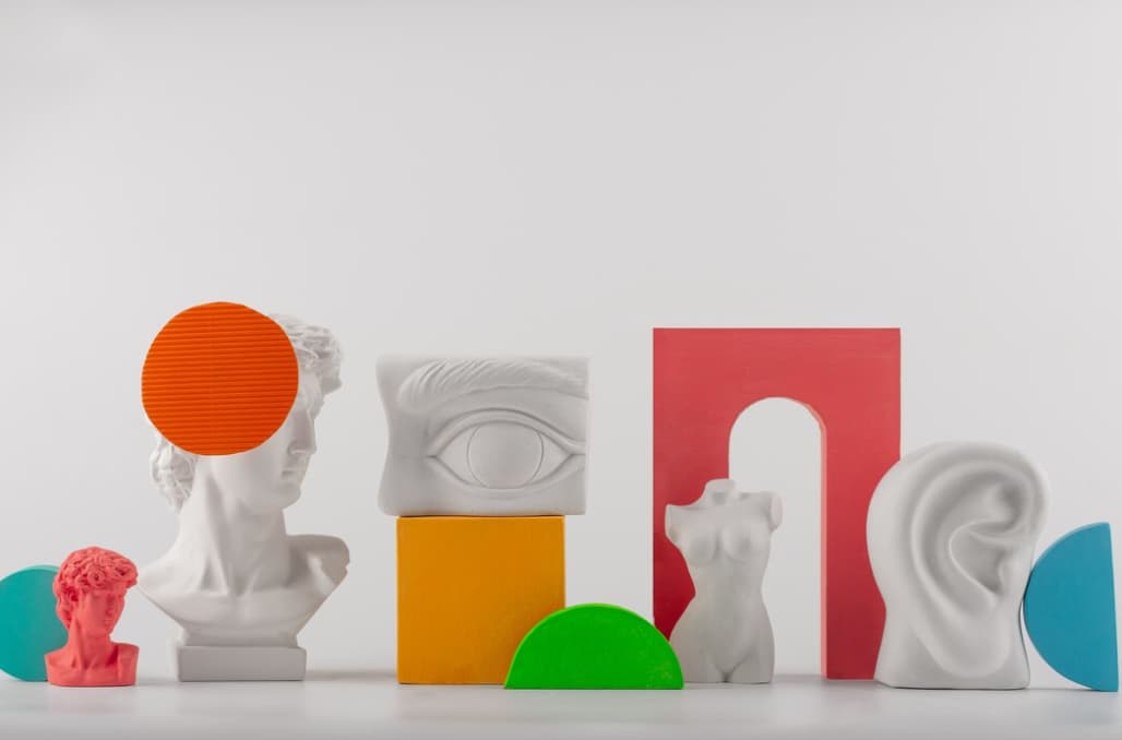 Assorted classical and abstract sculptures arranged with colorful shapes